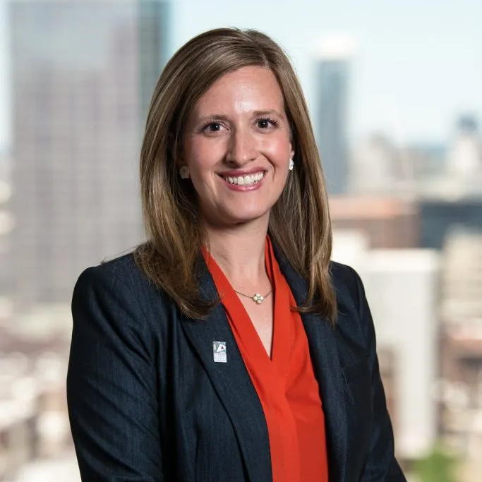 Rebecca Julien, Principal Rebecca Julien, Principal of Kirkbride School, smiling in a professional portrait with a blurred city background
